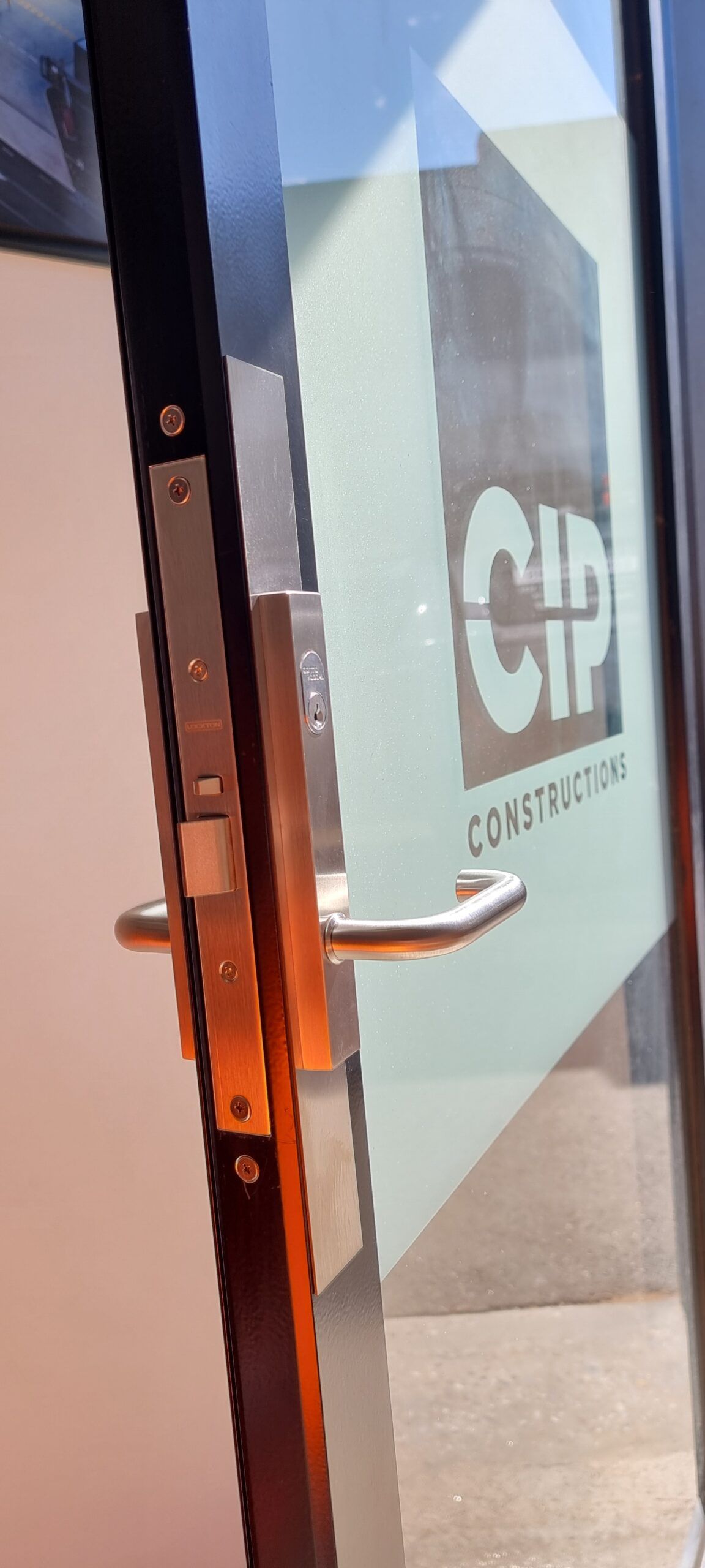 A commercial glass door fitted with a modern lock