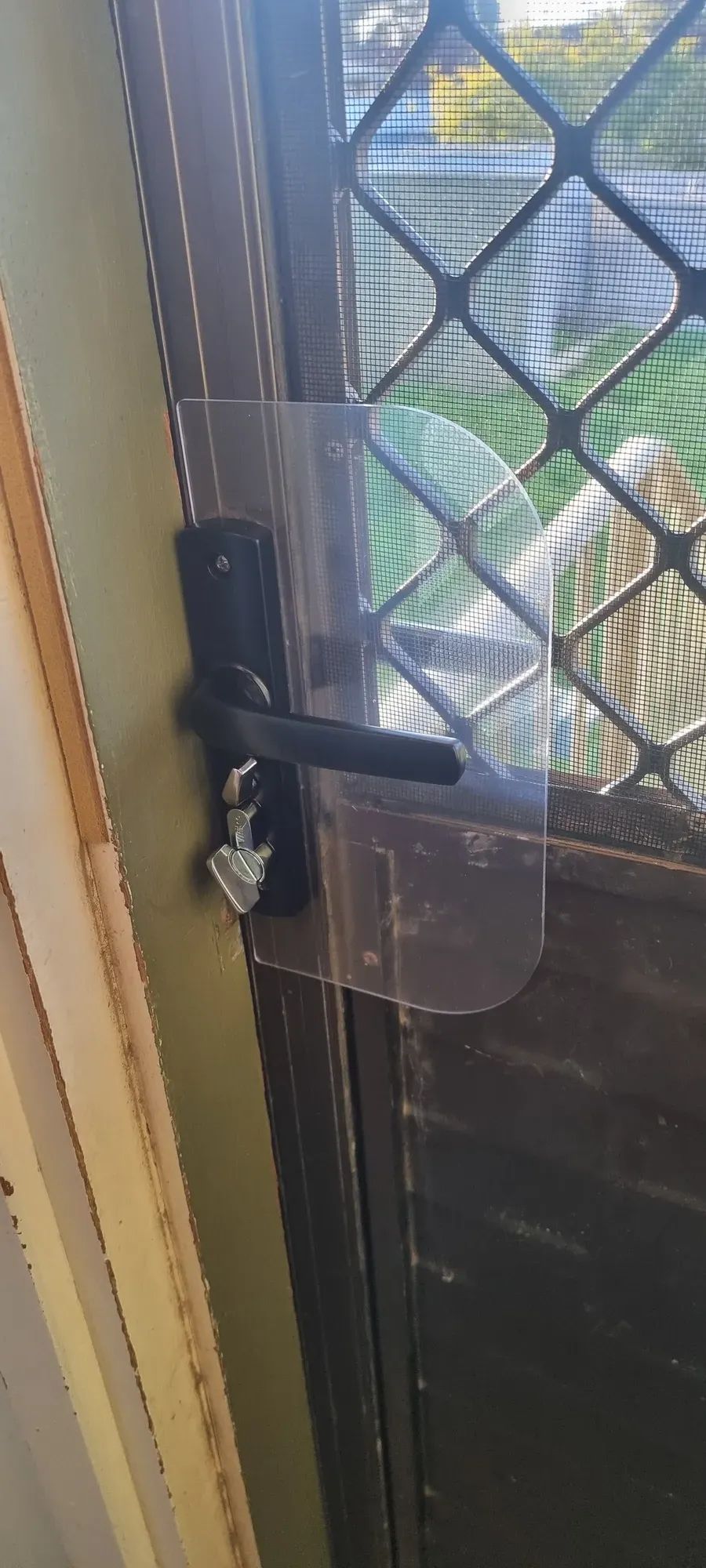 A black smart lock fitted to a screen door