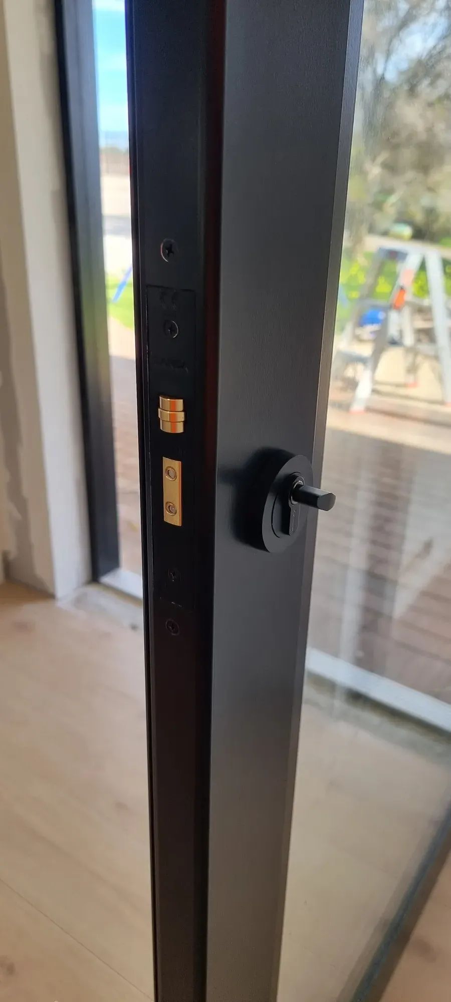 A black deadbolt on an aluminium door