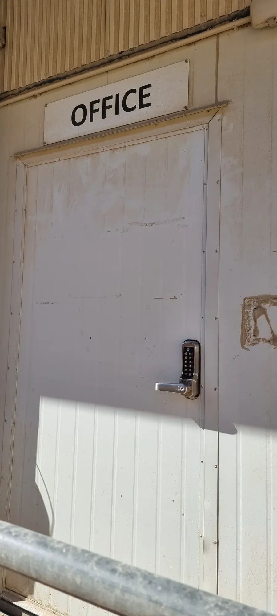 A mechanical keypad lock on a grey door