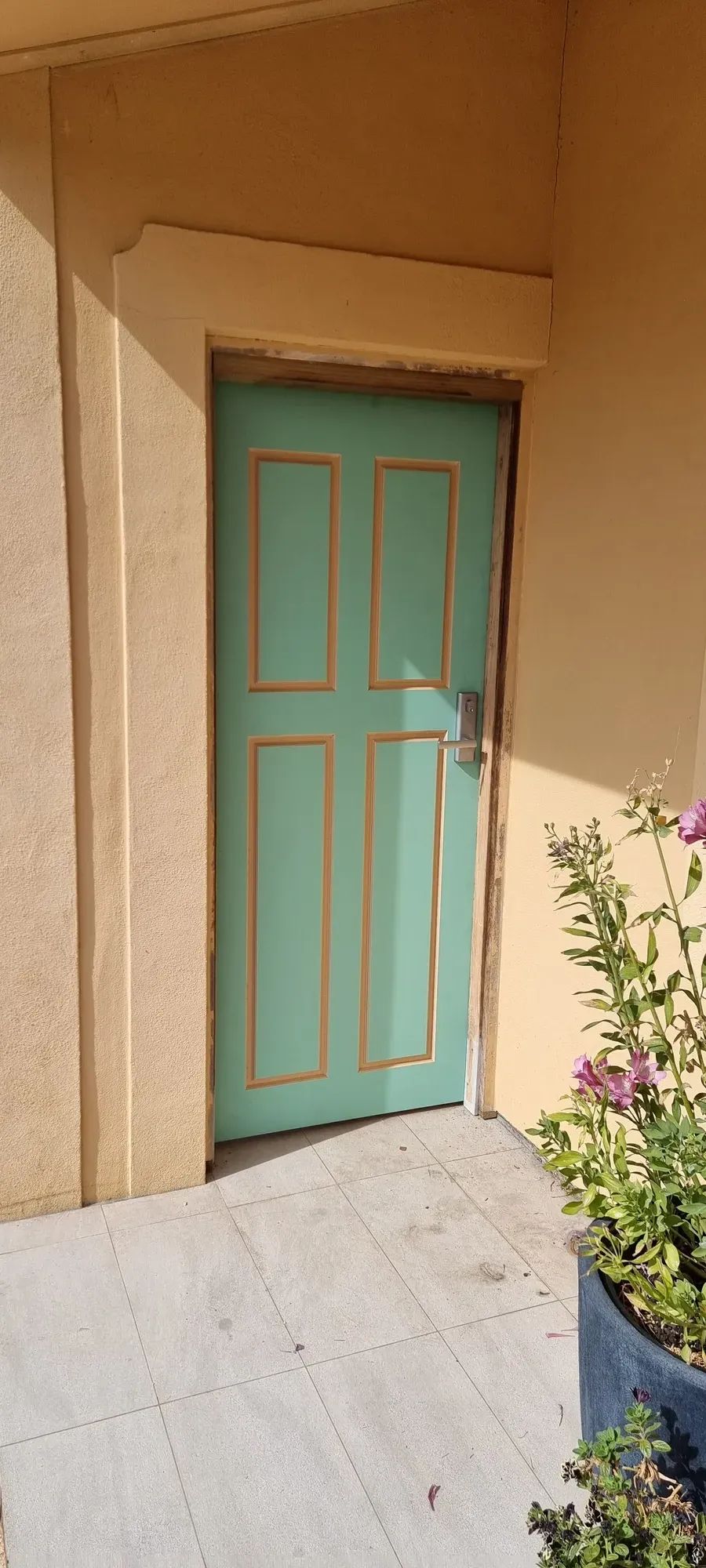 A teal front door fitted with a new lock