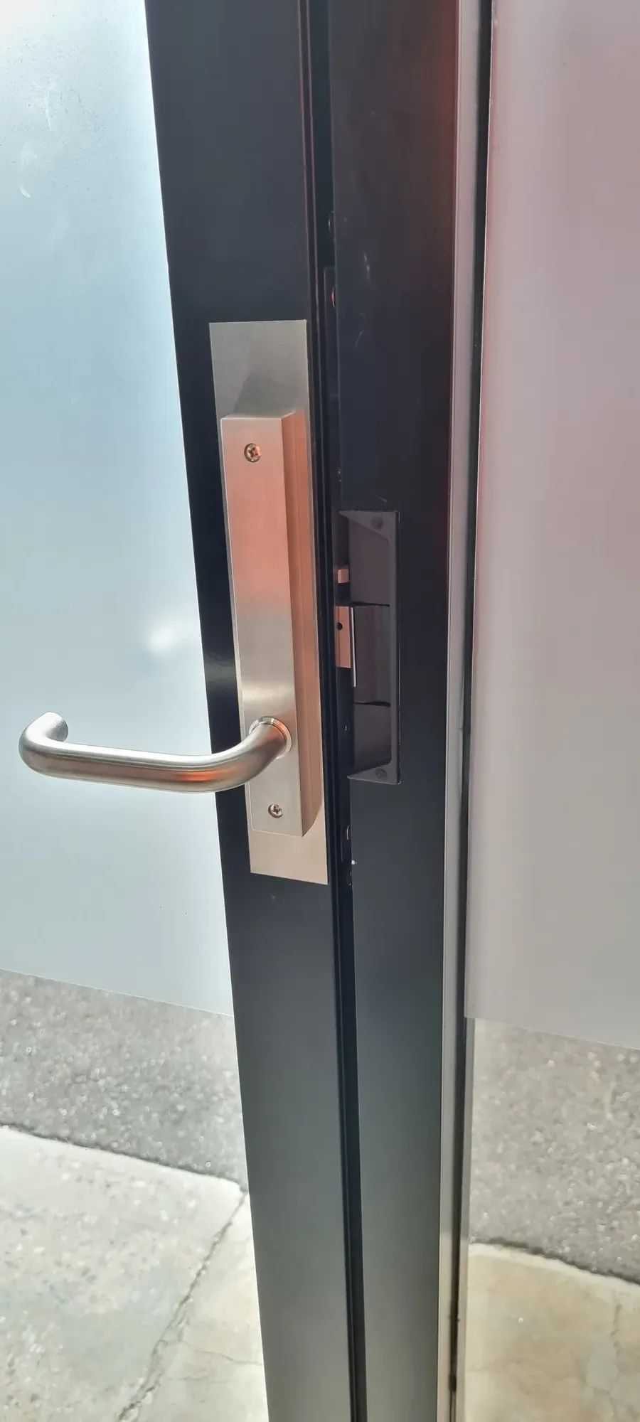 A stainless handle and lock on a glass door